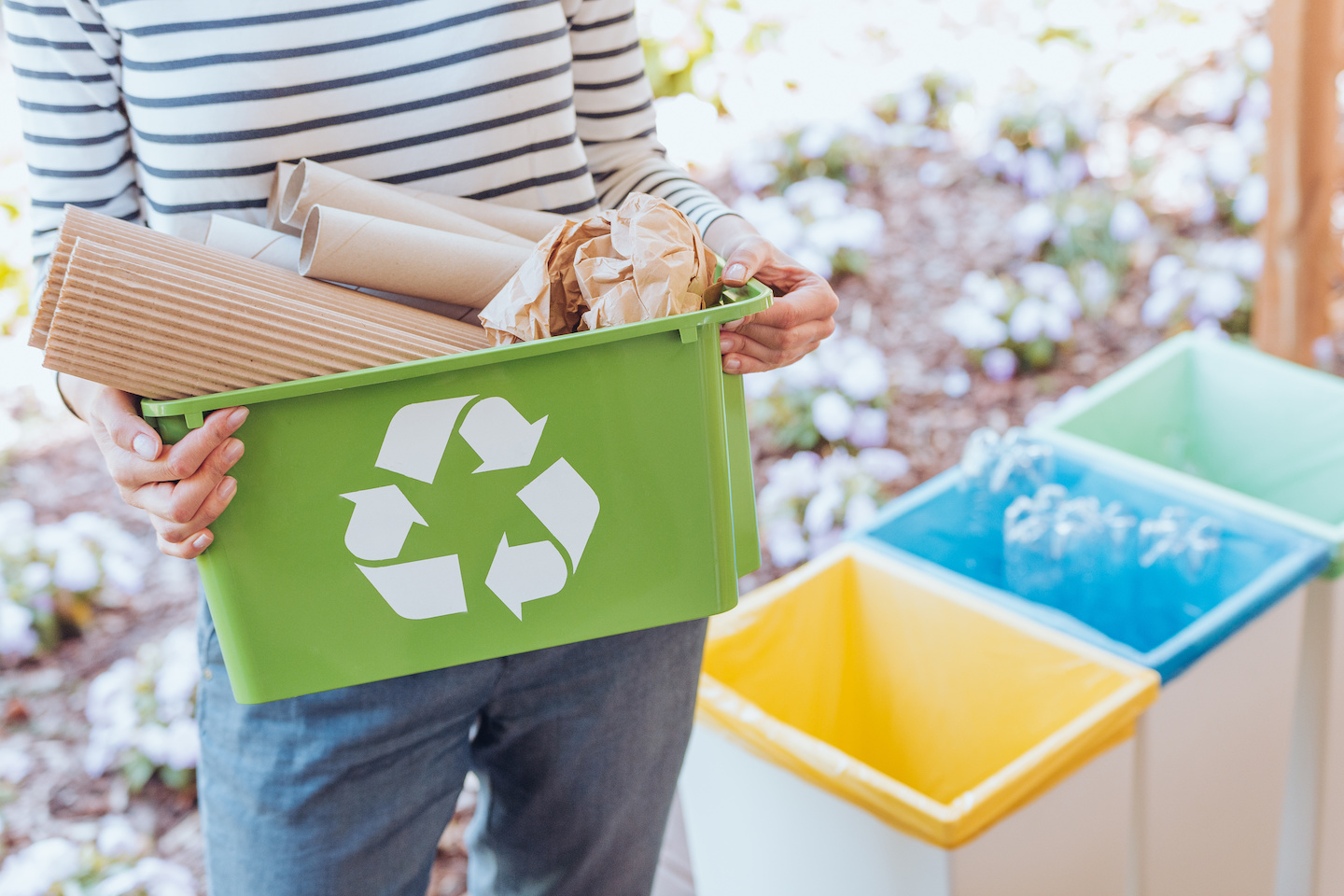 Activist taking care of environment during sorting paper waste to proper recycling bin on terrace